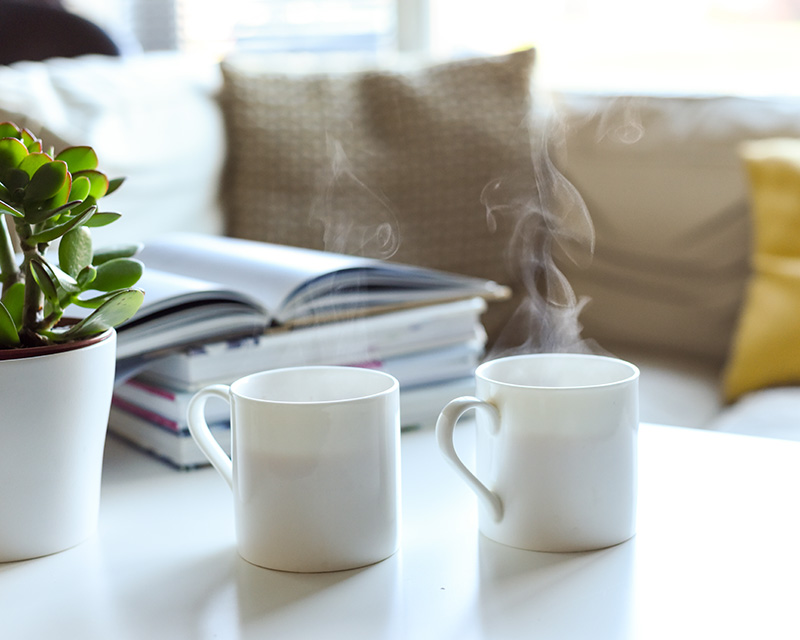 Two steaming mugs of tea on a coffee table in waiting room